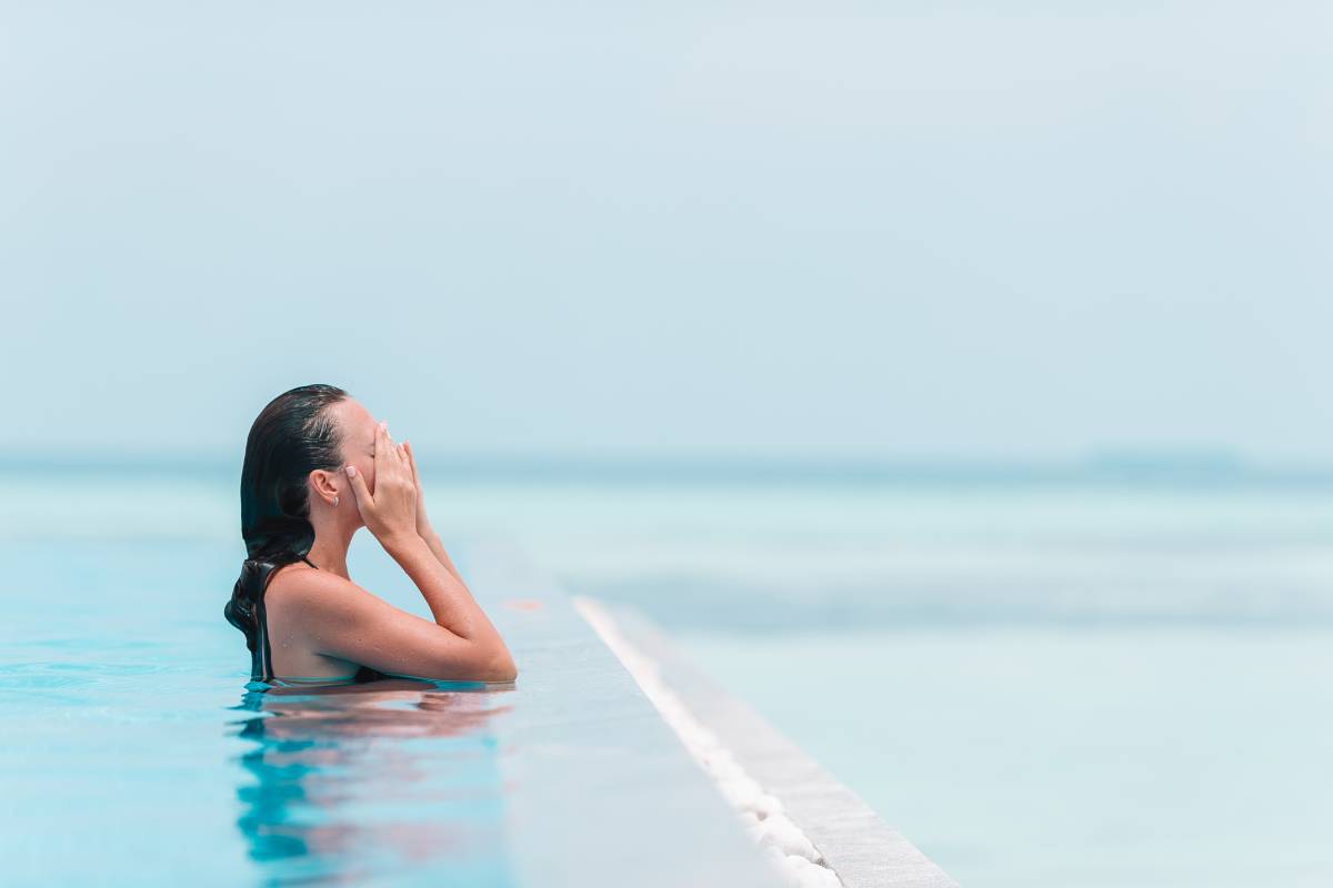 Young beautiful woman enjoying summer vacation in luxury swimming pool