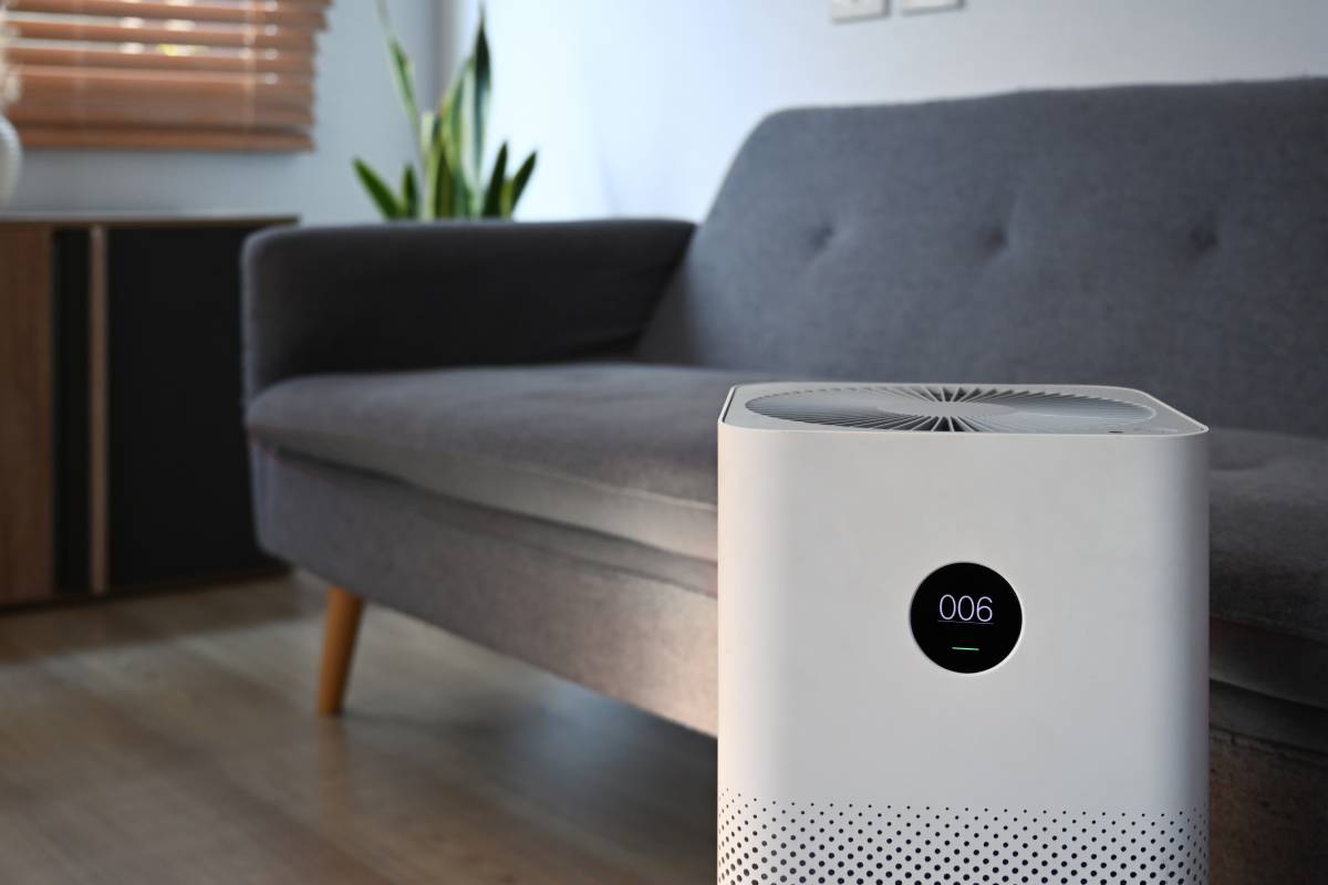 Modern air purifier on wooden floor in bright living room for filter and cleaning removing dust PM2.5.