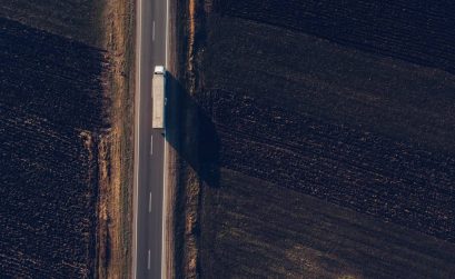 Aerial view of freight transportation truck on the road through countryside