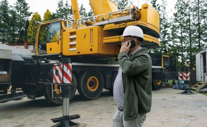 Foreman talking by phone on construction site. architect discussing project using smart phone, construction engineers planning building. Communication and safety. Man from the back (Foreman talking by phone on construction site. architect discussing p