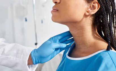 cropped view of Adam's apple in women african american woman when her indian doctor examining her lymph nodes